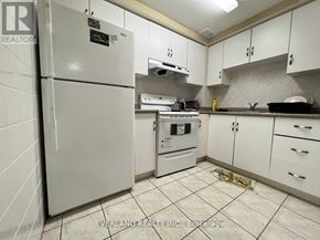 Markham (Cedarwood) house for rent - A kitchen with white cabinets and a white fridge.