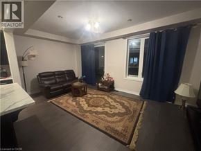 Hamilton townhouse for rent - A living room with a brown rug and a brown leather chair.