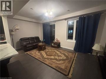 Hamilton townhouse for rent - A living room with a brown rug and a brown leather chair.