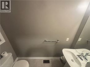 Hamilton townhouse for rent - A bathroom with a toilet, sink, and towel rack.