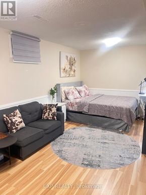 Ajax (Central West) house for rent - A bedroom with a bed, couch, and rug.