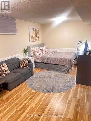 Ajax (Central West) house for rent - A bedroom with a bed, couch, and a rug.