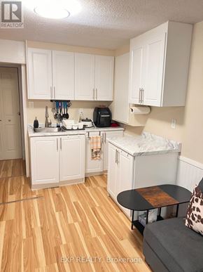 Ajax (Central West) house for rent - A kitchen with white cabinets and a wooden floor.
