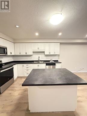 Norfolk (Simcoe) townhouse for rent - A kitchen with white cabinets and a black counter top.