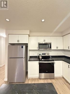 Norfolk (Simcoe) townhouse for rent - A kitchen with a refrigerator, microwave, and stove.