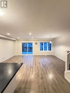 Norfolk (Simcoe) townhouse for rent - A spacious room with wooden flooring and a black countertop.