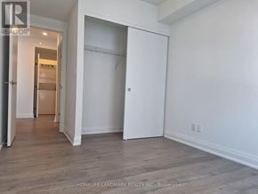 Barrie (Alliance) condo for rent - A room with a white wall and a wooden floor.