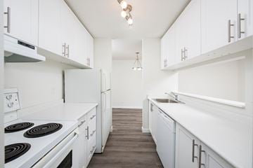 Edmonton apartment for rent - A kitchen with white cabinets and a stove top oven.