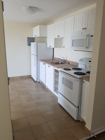 Halifax apartment for rent - A kitchen with white appliances and cabinets.