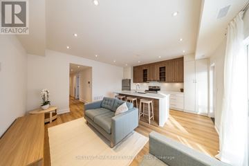 Toronto (Caledonia-Fairbank) fourplex for rent - A modern living room with a grey sofa and wooden floors.