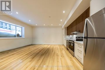 Toronto (Caledonia-Fairbank) fourplex for rent - A kitchen with wooden floors and stainless steel appliances.