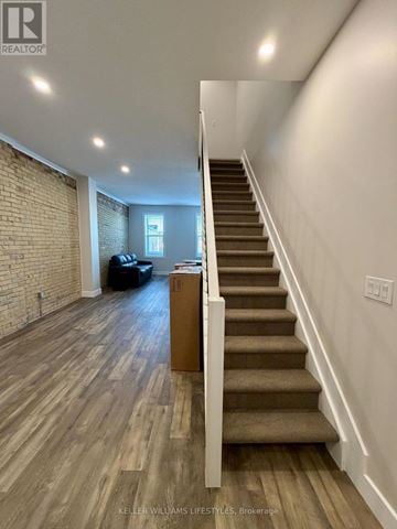 St. Thomas multi-family for rent - A staircase with wooden steps and a white railing leads to a living room with a couch and a coffee table.