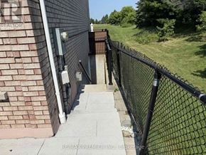 Vaughan (Elder Mills) house for rent - A black metal fence runs along the side of a brick building.