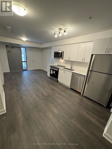 Toronto (Victoria Village) townhouse for rent - A kitchen with white cabinets and a grey floor.