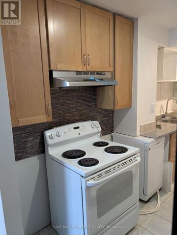 Barrie (Georgian Drive) house for rent - A white stove and dishwasher in a kitchen with wooden cabinets.