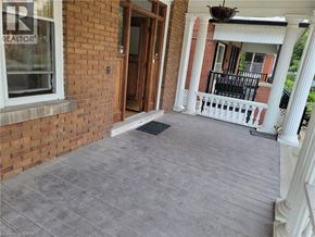 Hamilton house for rent - A porch with a grey floor and a white railing.