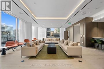 Toronto (Mount Pleasant West) condo for rent - A spacious living room with a long white sofa and a green rug.