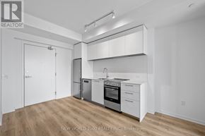 Toronto (Mount Pleasant West) condo for rent - A kitchen with white cabinets and appliances in a white room.