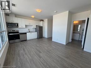 Kitchener condo for rent - A room with a window and wooden flooring.