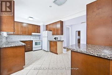 Hamilton (Ainslie Wood) multi-family for rent - A kitchen with brown cabinets and a granite countertop.
