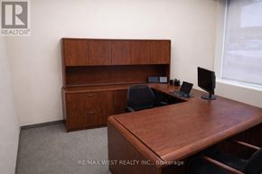 For rent in Toronto (Weston) - A brown desk with a computer and a chair in a room.
