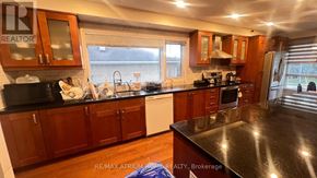 Toronto (Newtonbrook East) house for rent - A kitchen with wooden cabinets and black countertops.