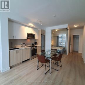 Toronto (Islington-City Centre West) condo for rent - A modern kitchen with a glass table and chairs.