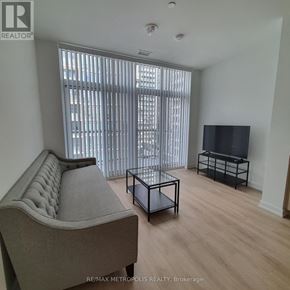 Toronto (Islington-City Centre West) condo for rent - A living room with a grey sofa, a black coffee table, and a flat screen TV.