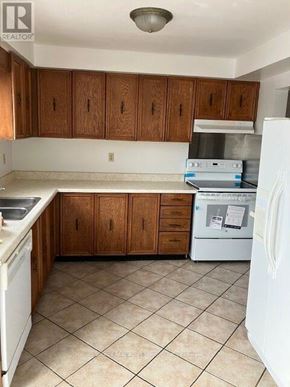 Ajax (Central) house for rent - A kitchen with white appliances and brown cabinets.