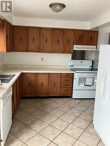 Ajax (Central) house for rent - A kitchen with white appliances and brown cabinets.