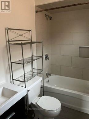 Ajax (Central) house for rent - A white toilet sits in a bathroom with a white bathtub.