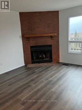 Ajax (Central) house for rent - A room with a fireplace and wooden flooring.