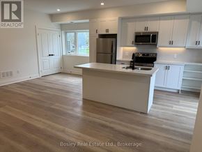 Collingwood townhouse for rent - A kitchen with a white island and wooden floors.