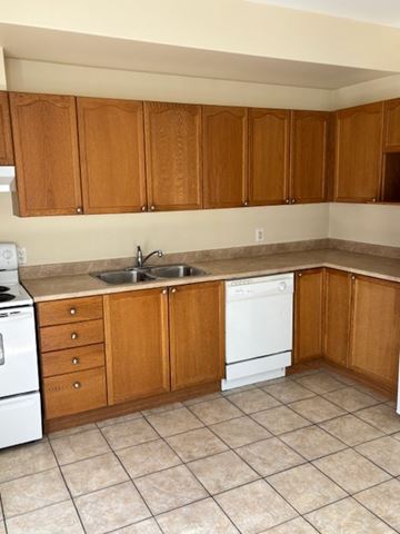 Bridgewater apartment for rent - A kitchen with wooden cabinets and a white dishwasher.