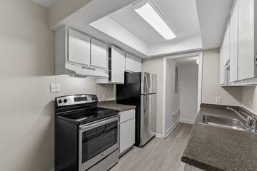 Macon apartment for rent - A kitchen with black appliances and white cabinets.