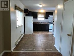 Toronto (Scarborough Village) house for rent - A kitchen with black cabinets and a white refrigerator.