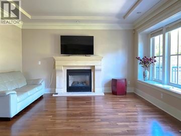 Vancouver house for rent - A living room with a fireplace and a television on the wall.