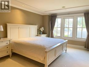 Vancouver house for rent - A bedroom with a bed, nightstand, and window.