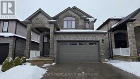 London North (North C) house for rent - A house with a snow-covered front yard and a garage door.