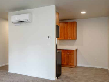 Federal Way apartment for rent - A black refrigerator is in a kitchen with wooden cabinets.