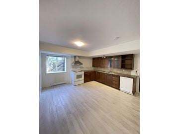 Surrey house for rent - A kitchen with white appliances and wooden cabinets.