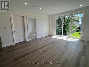 Niagara Falls (Brown) house for rent - A room with wooden flooring and white walls, with a window showing greenery outside.