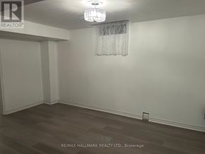 Whitchurch-Stouffville (Stouffville) house for rent - A room with a chandelier and a wooden floor.