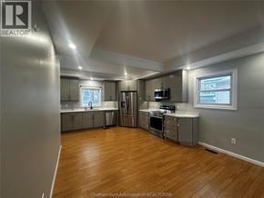 Merlin house for rent - A spacious kitchen with wood flooring and stainless steel appliances.