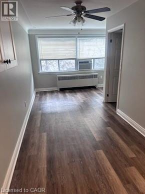 Hamilton apartment for rent - A room with wood flooring and a ceiling fan.