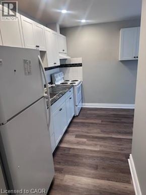 Hamilton apartment for rent - A kitchen with white cabinets and a white fridge.