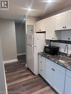 Hamilton apartment for rent - A kitchen with white cabinets and a white fridge.