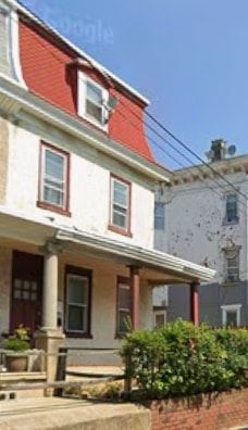 Philadelphia apartment for rent - A white house with a red roof and a porch.