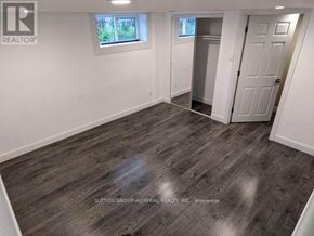 Toronto (Wexford-Maryvale) house for rent - A room with wooden flooring and white walls, with a door leading to another room.