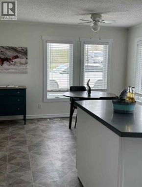 For rent in Rural Cardston County - A kitchen with a black counter top and a ceiling fan.